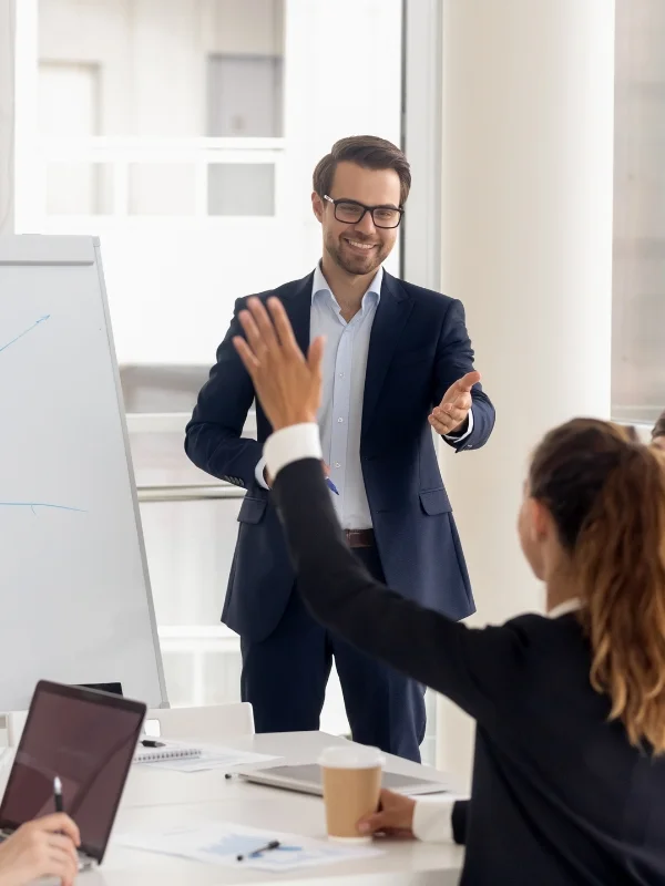 Trainer motiviert Teilnehmer im Seminarraum, interaktive Beteiligung und praxisorientierte Übungen während professioneller Sales Trainings.