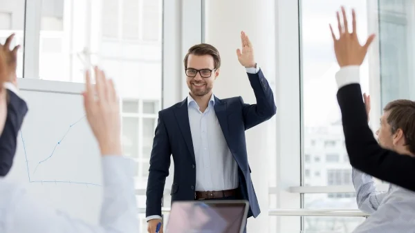 Trainer interagiert mit Teilnehmern im Seminarraum, motivierende Beteiligung und aktive Mitarbeit während praxisnaher Sales Trainings.