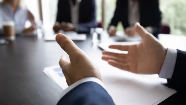 Gestikulierende Hände im Meeting verdeutlichen Argumentation, aktiver Austausch und praxisnahe Kommunikation während professioneller Sales Trainings.