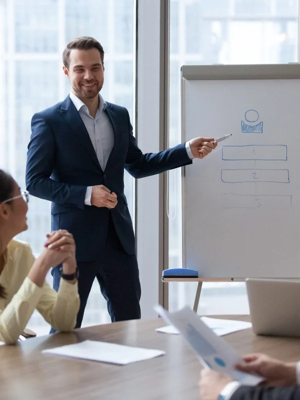 Trainer präsentiert Inhalte am Flipchart, Teilnehmer verfolgen aufmerksam praxisnahe Übungen in Seminare Persönlichkeitsentwicklung im modernen Konferenzraum.