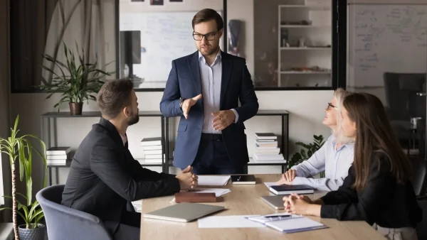 Trainer moderiert Gruppenarbeit im Meetingraum, fördert Kommunikation, Selbstreflexion und Wachstum durch Seminare Persönlichkeitsentwicklung.