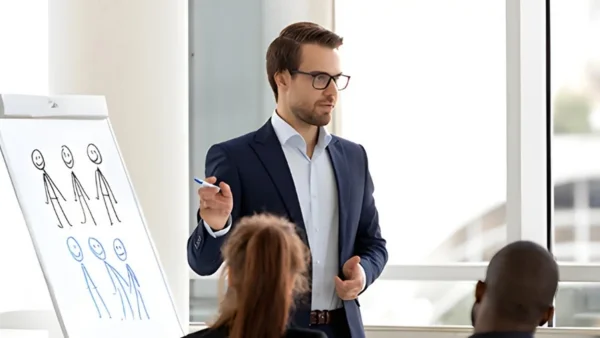 Berater präsentiert am Flipchart vor Team, anschauliche Zielgruppenanalyse und strategische Beratung durch Lessig Consulting im modernen Konferenzraum.