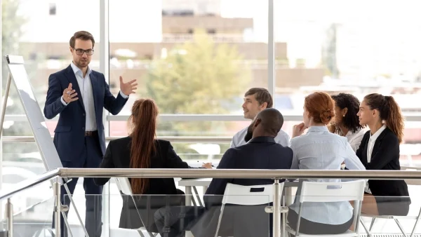 Berater präsentiert vor Team im modernen Konferenzraum, interaktive Schulung und Strategieentwicklung bei Lessig Consulting.