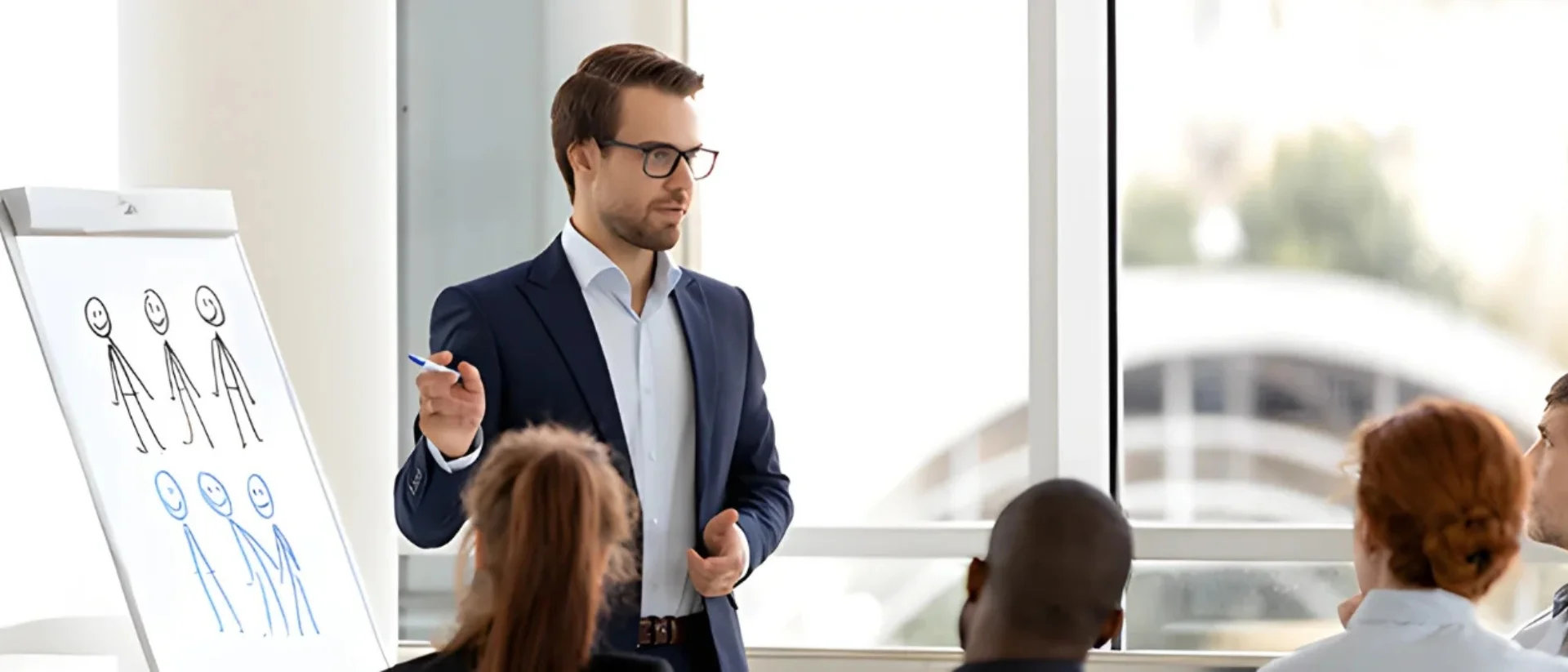 Berater präsentiert am Flipchart vor Team, anschauliche Zielgruppenanalyse und strategische Beratung durch Lessig Consulting im modernen Konferenzraum.